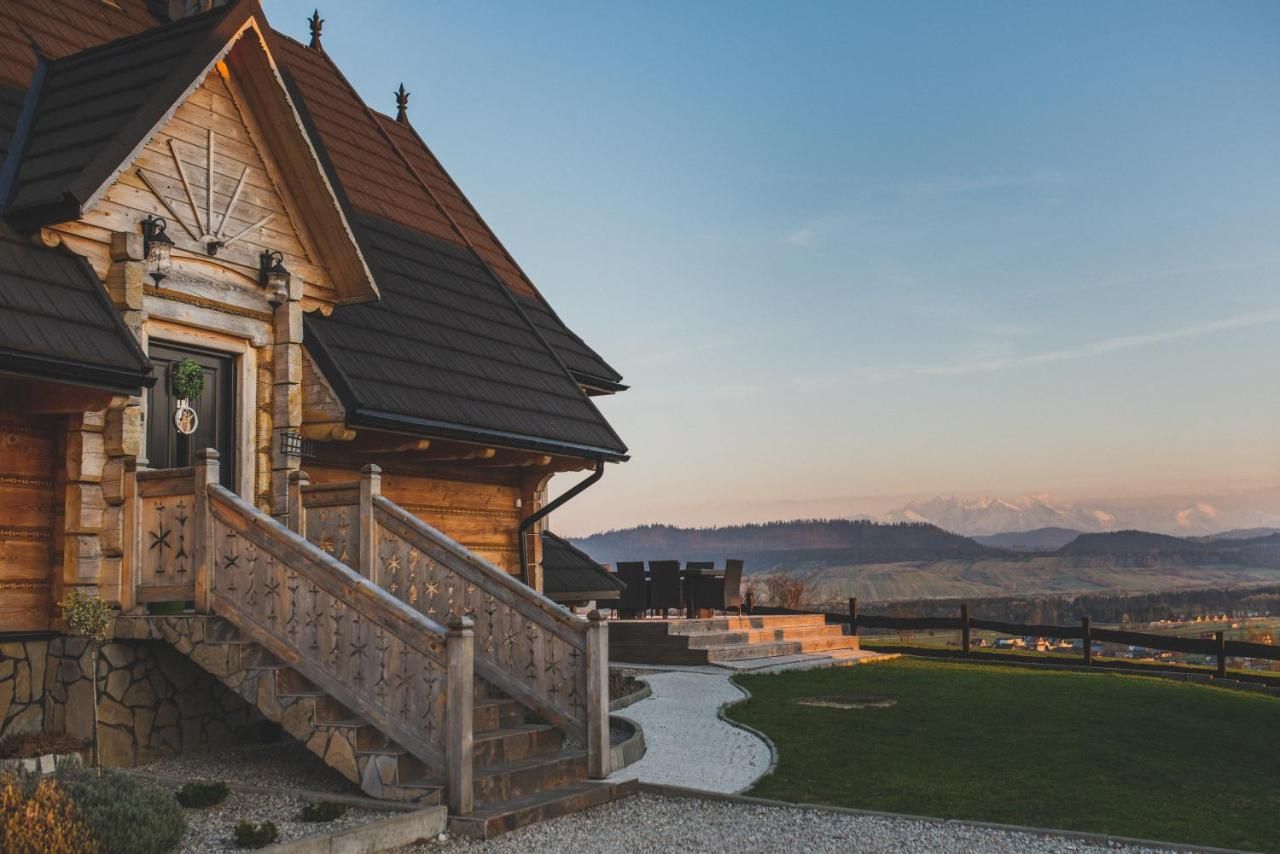 Drewniany dom Jaworowy z tarasem i panoramą Tatr o zachodzie słońca
